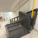 Інвалідний підйомник похилого типу з металевою платформою та захисними поручнями для переміщення по сходах