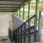 Похилий підйомник для інвалідного візка з напрямними рейками вздовж сходів