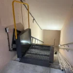 Надійний похилий підйомник для інвалідних візків, встановлений на сходах у підʼїзді