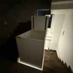 Вантажний вертикальний підйомник у шахті між поверхами, вигляд зверху під час роботи