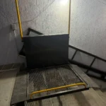 Інвалідний підйомник на сходах з захисними поручнями та сітчастою платформою